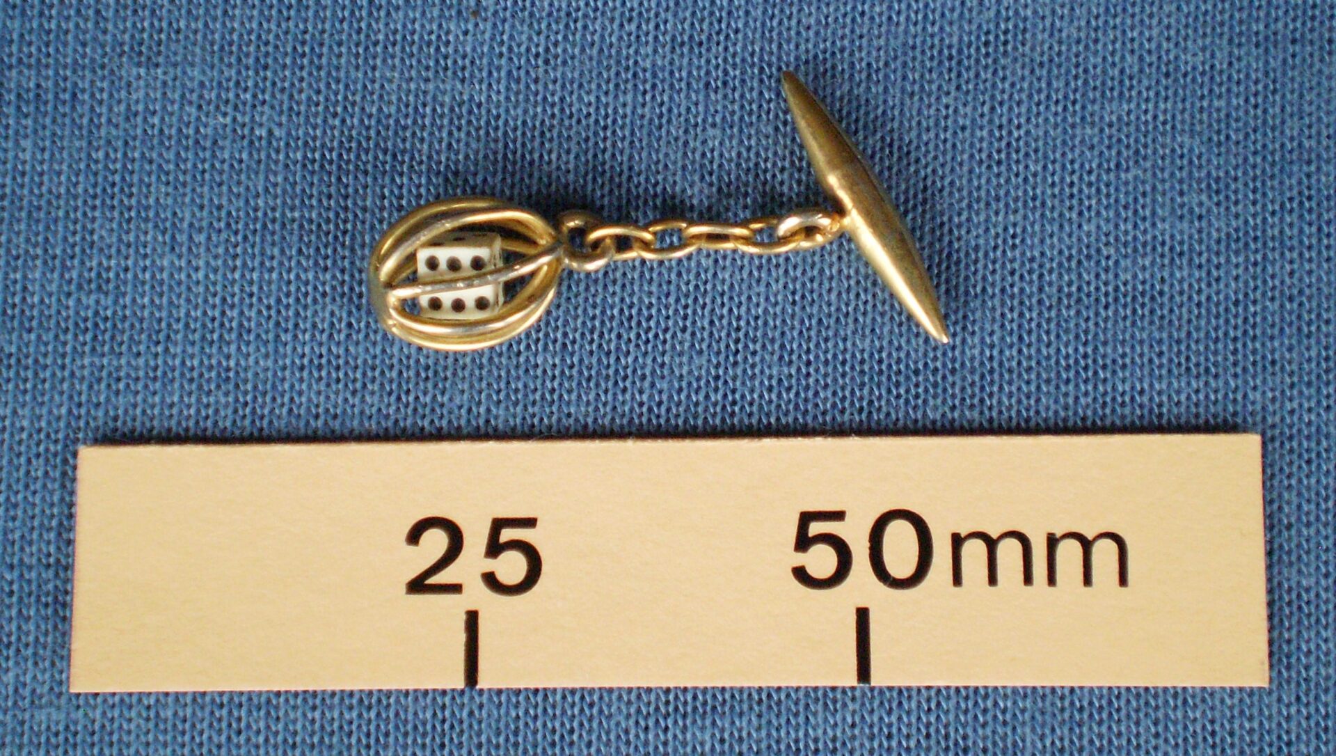 Single cufflink with a die in a cage