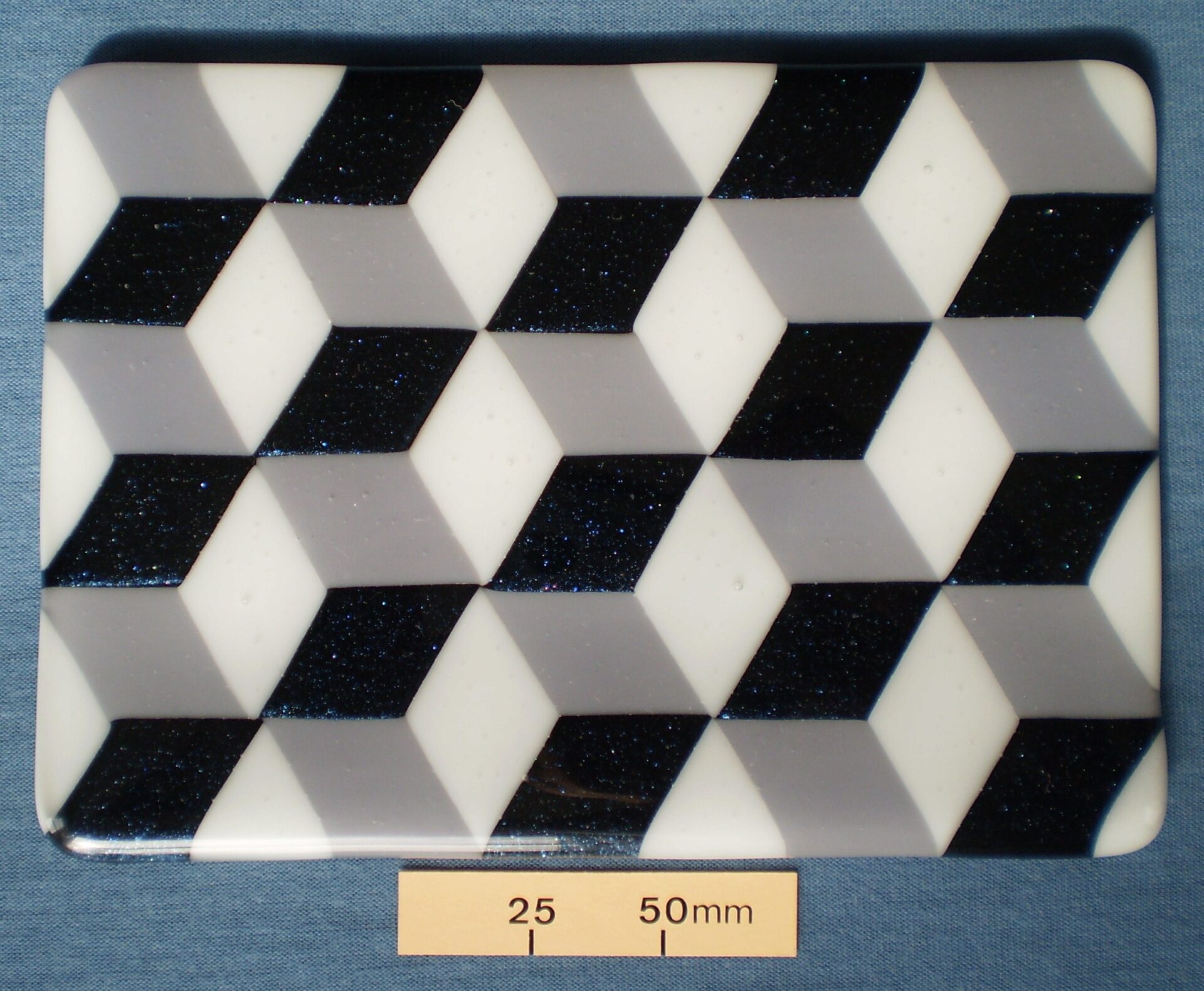 Kiln formed glass plate with optical illusion pattern