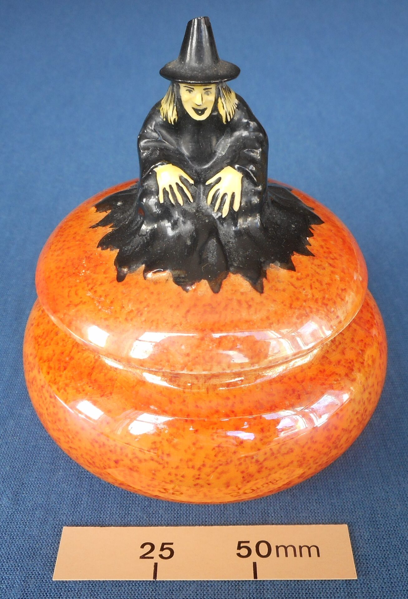 Ornamental pot: a witch on top of a pumpkin