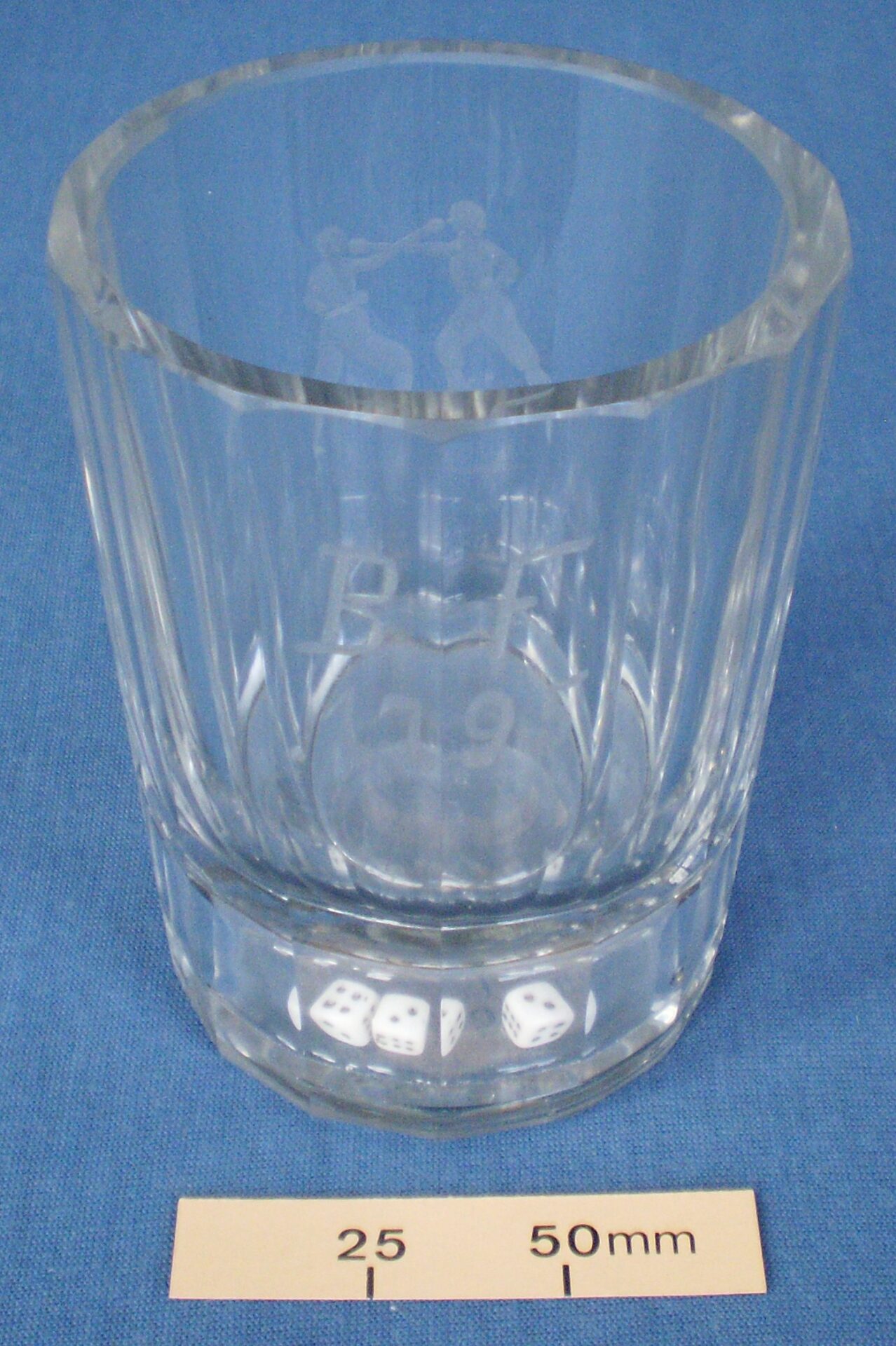 Glass tumbler with dice in the base and etched decorations