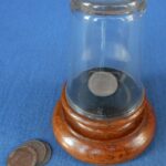An early coins in upturned glass trick
