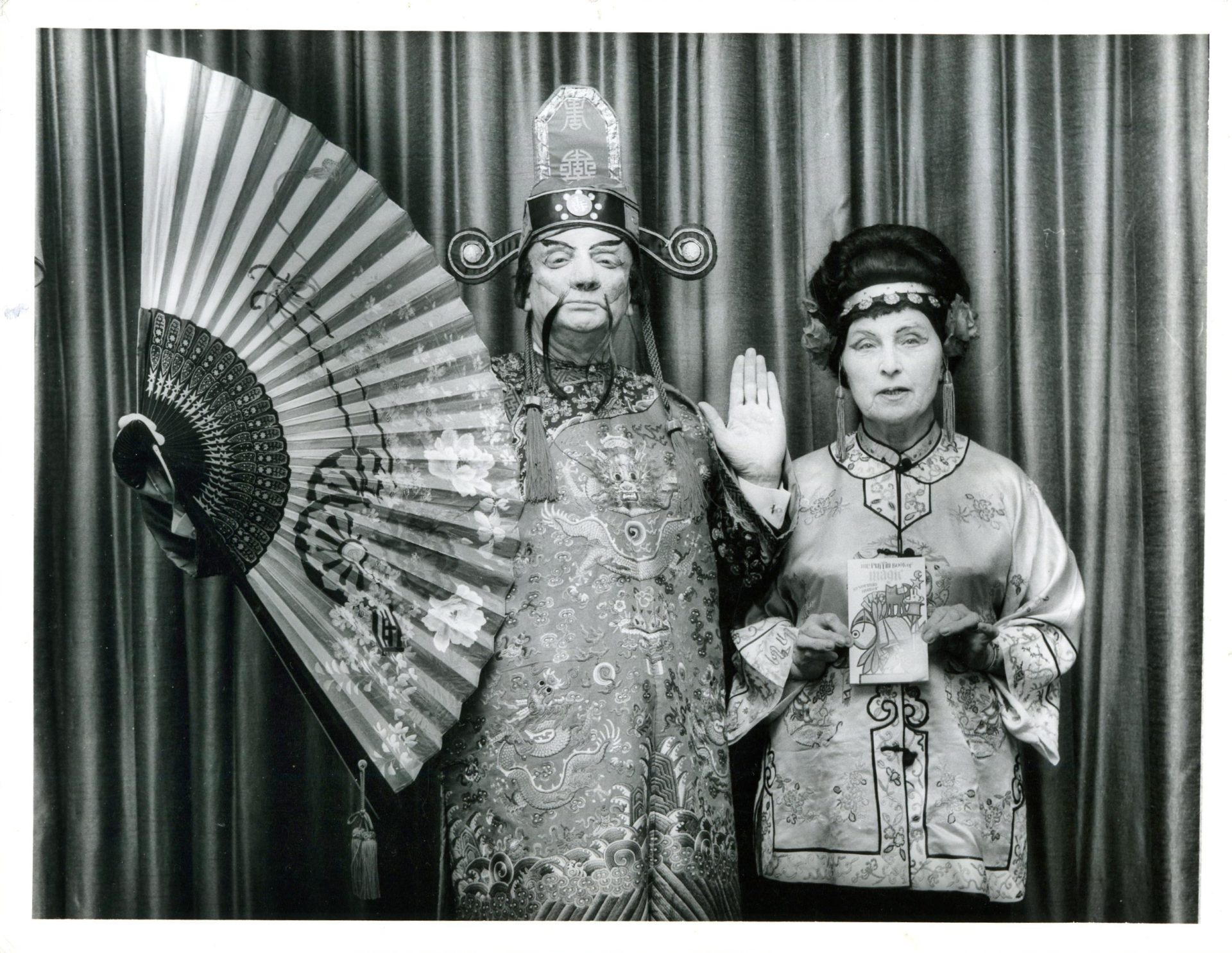 Norman Hunter in Chinese costume with his wife Sylvia holding ‘The Puffin Book of Magic’